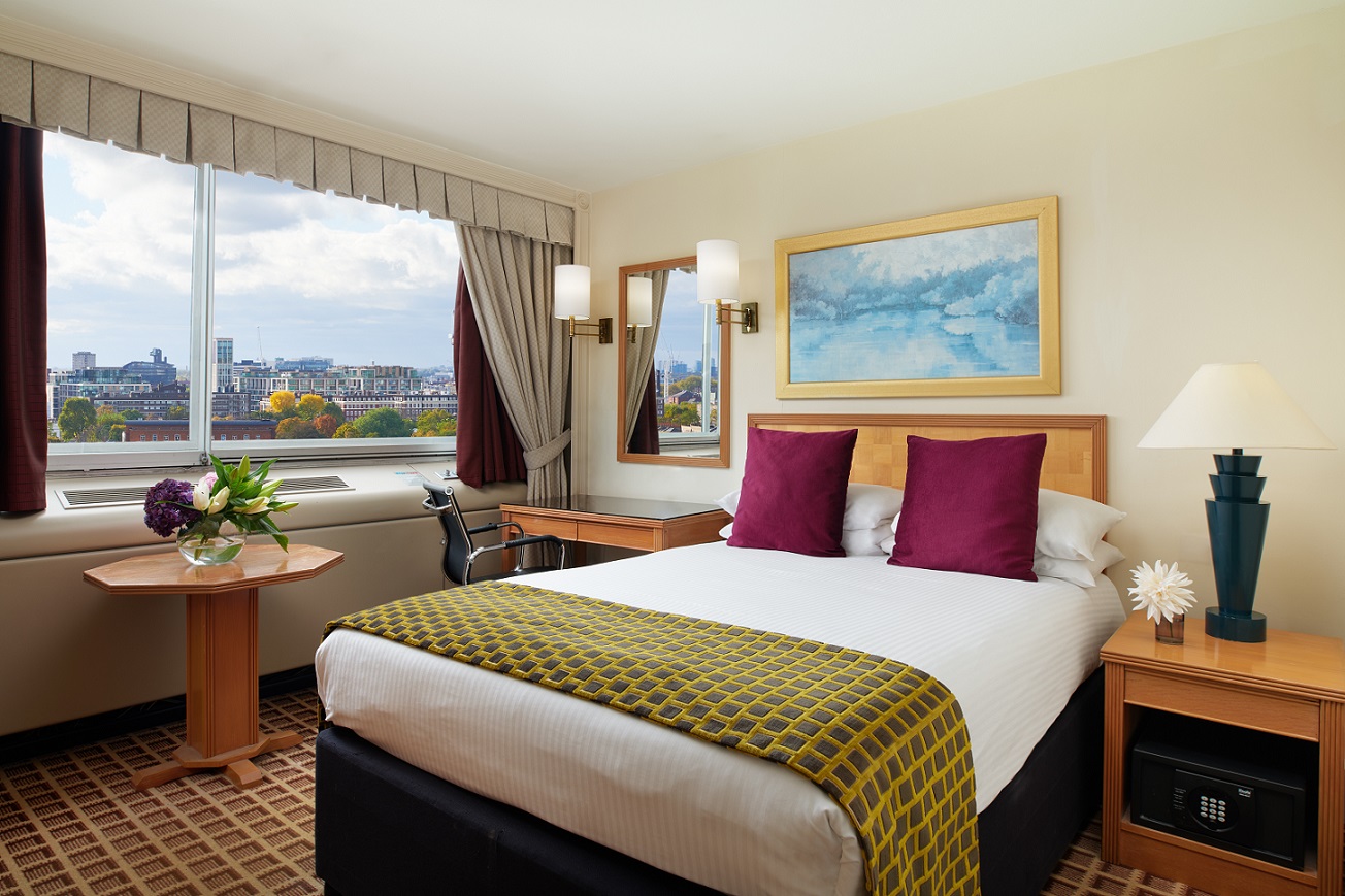 Superior Room at Copthorne Tara Hotel London Kensington with a double bed, upholstered headboard, desk and large window overlooking Kensington