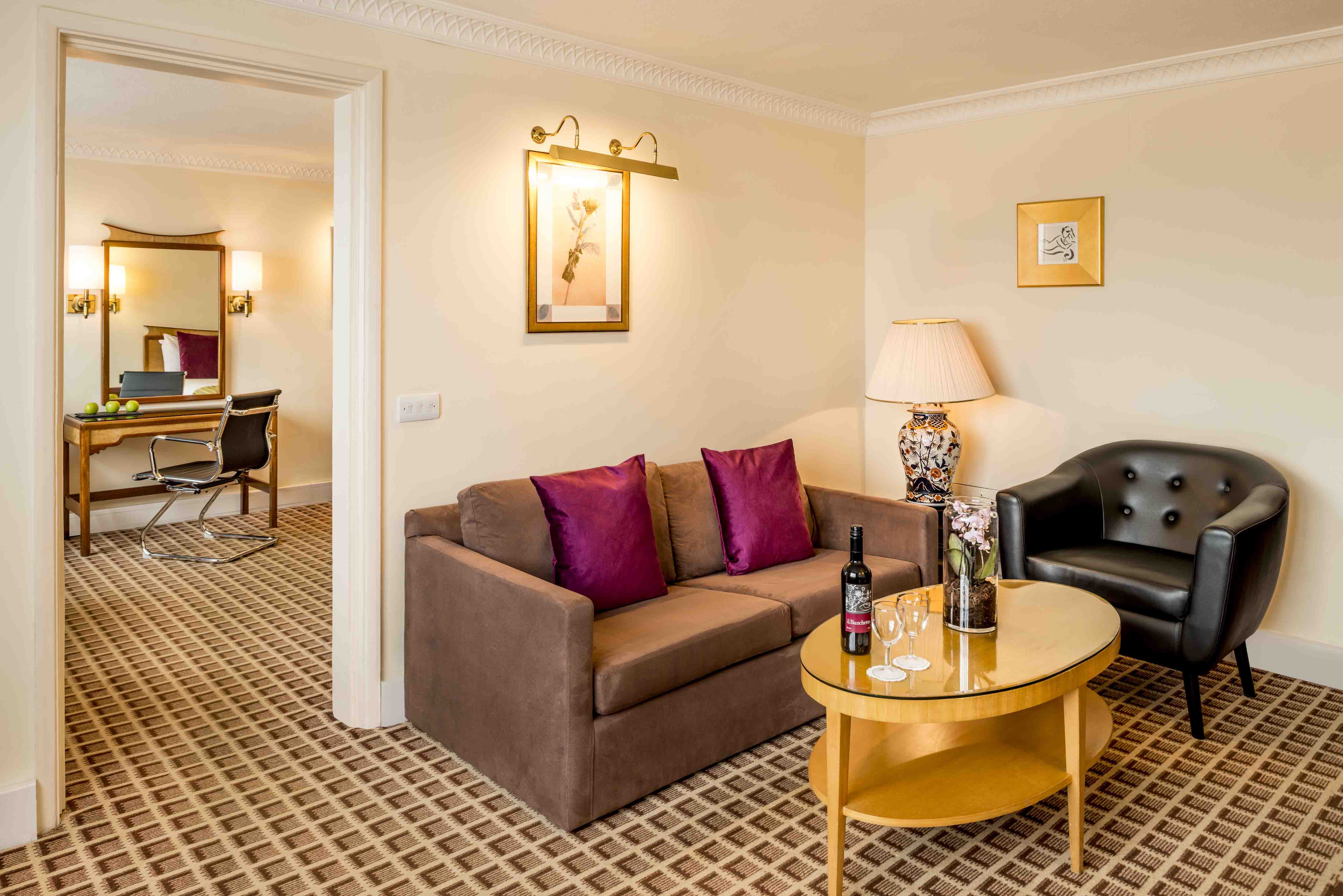 Executive Suite on the twelfth floor of Copthorne Tara Hotel London Kensington with a separate seating area, dining table and panoramic city views