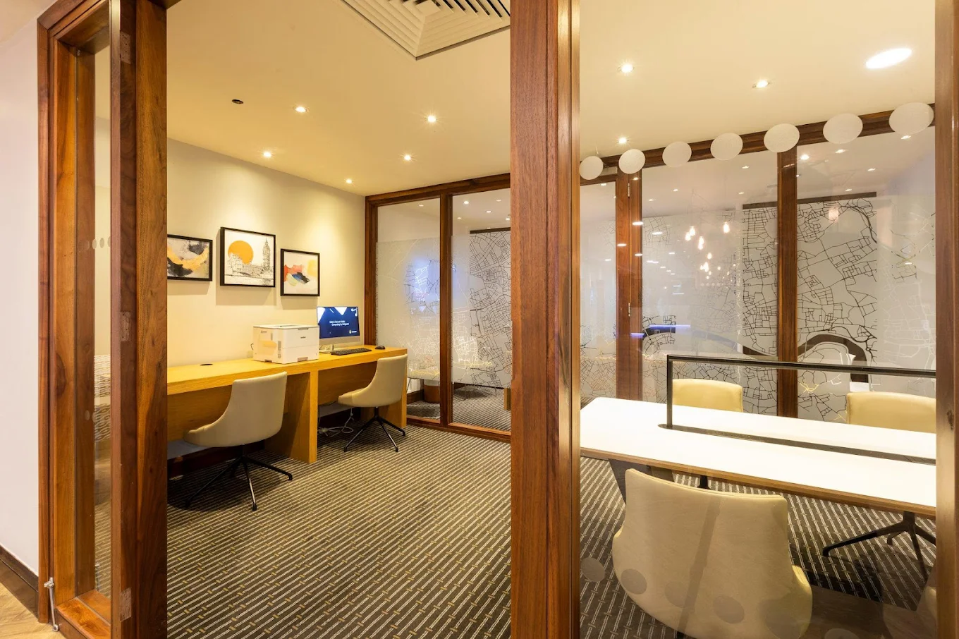 Business centre at Holiday Inn London Regent's Park with printer, computer workstation and glass-walled meeting rooms decorated with London street map artwork
