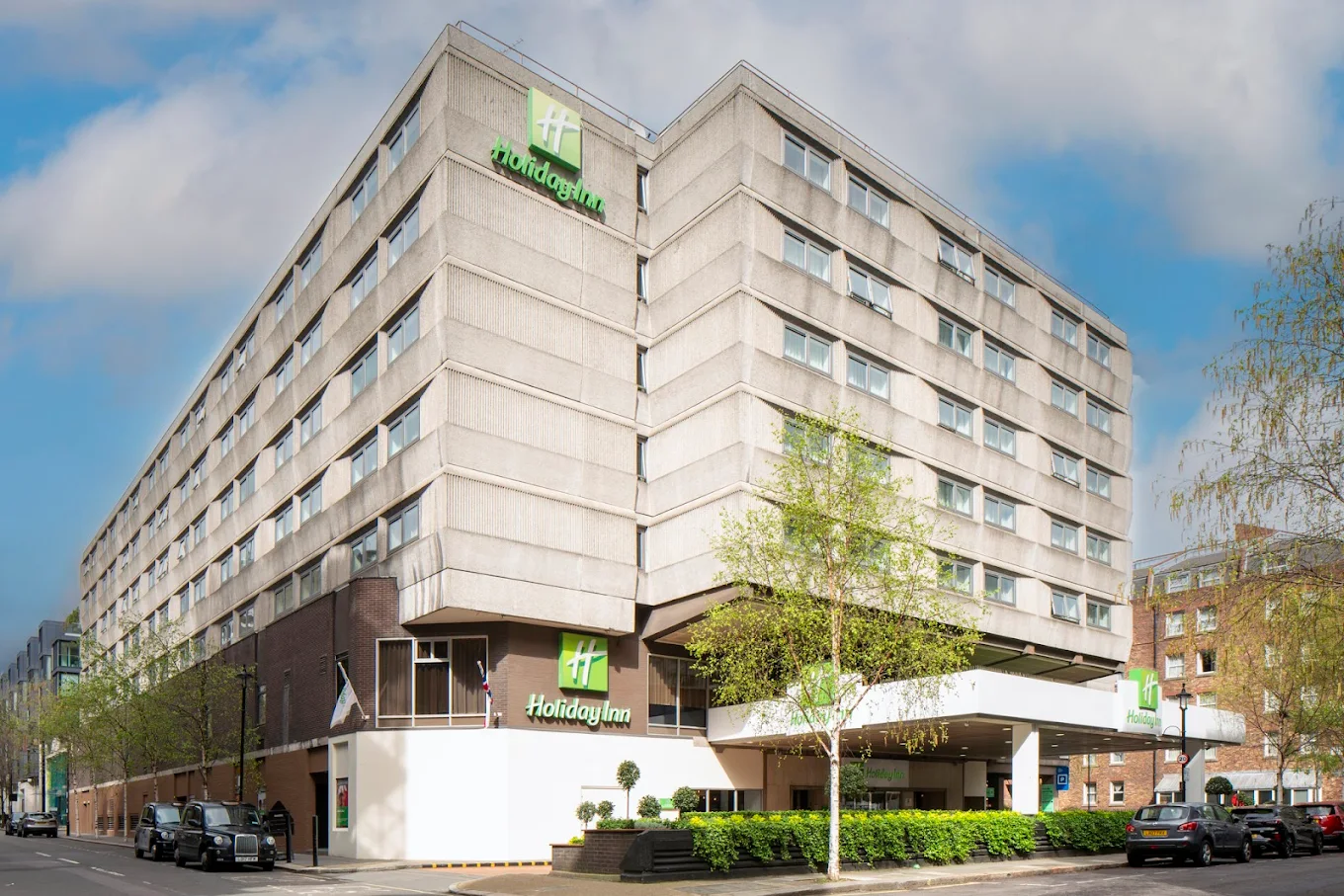 Holiday Inn London Regent's Park hotel exterior on Carburton Street in Fitzrovia with a black London cab passing in front