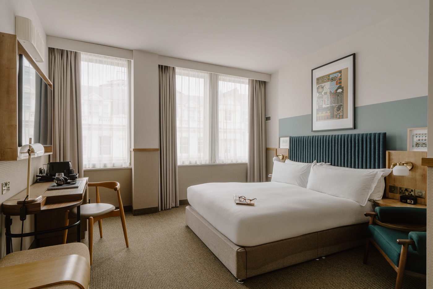 Standard room at Club Quarters Hotel, St Paul's, with wood panelling, a large bed and a workstation