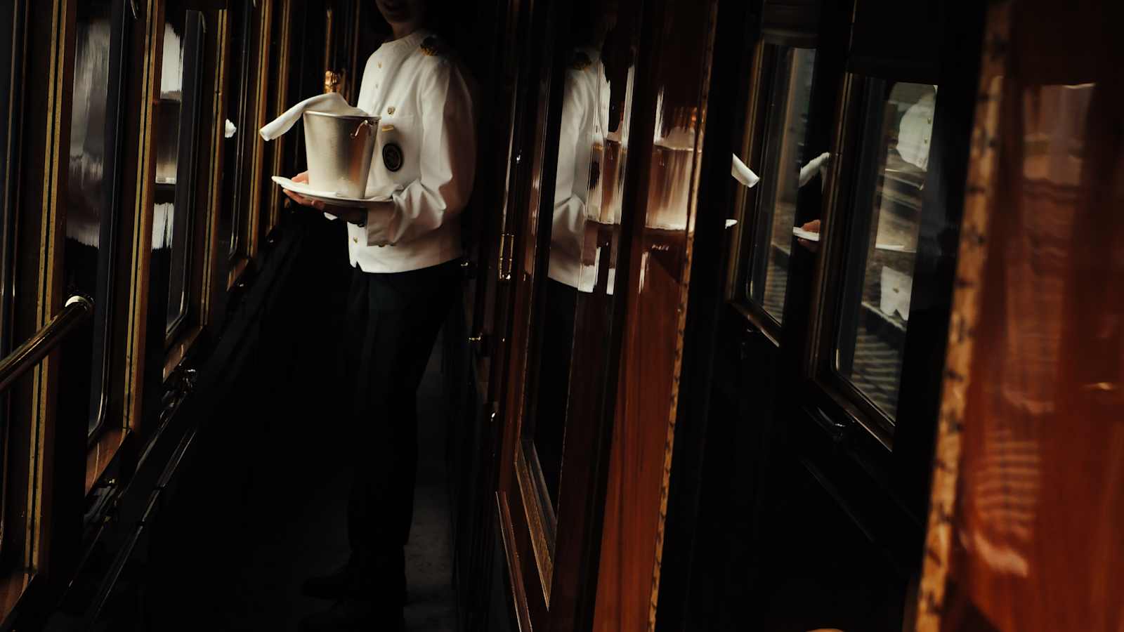 Private cabin on the Venice Simplon-Orient-Express with marquetry panelling and a made-up bed