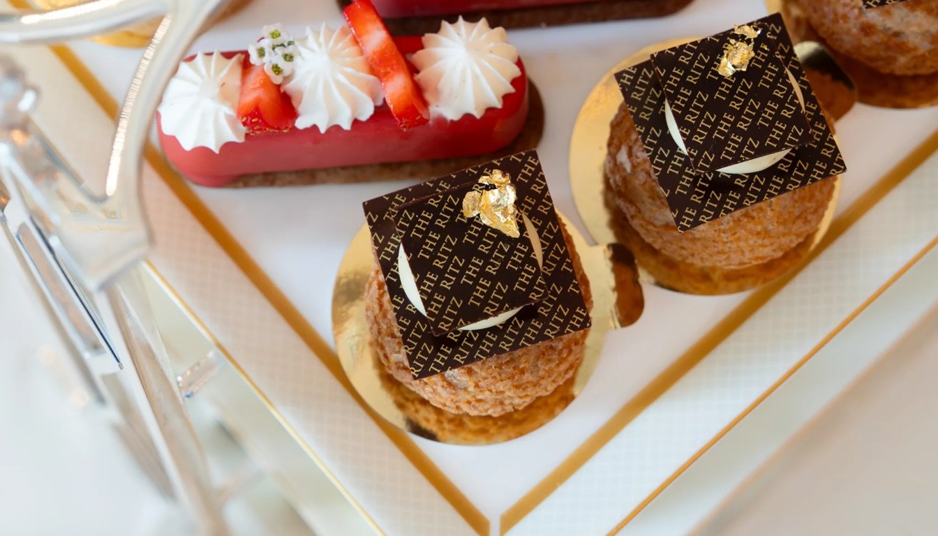 Pastries branded The Ritz with gold leaf on a tiered stand at the Palm Court afternoon tea