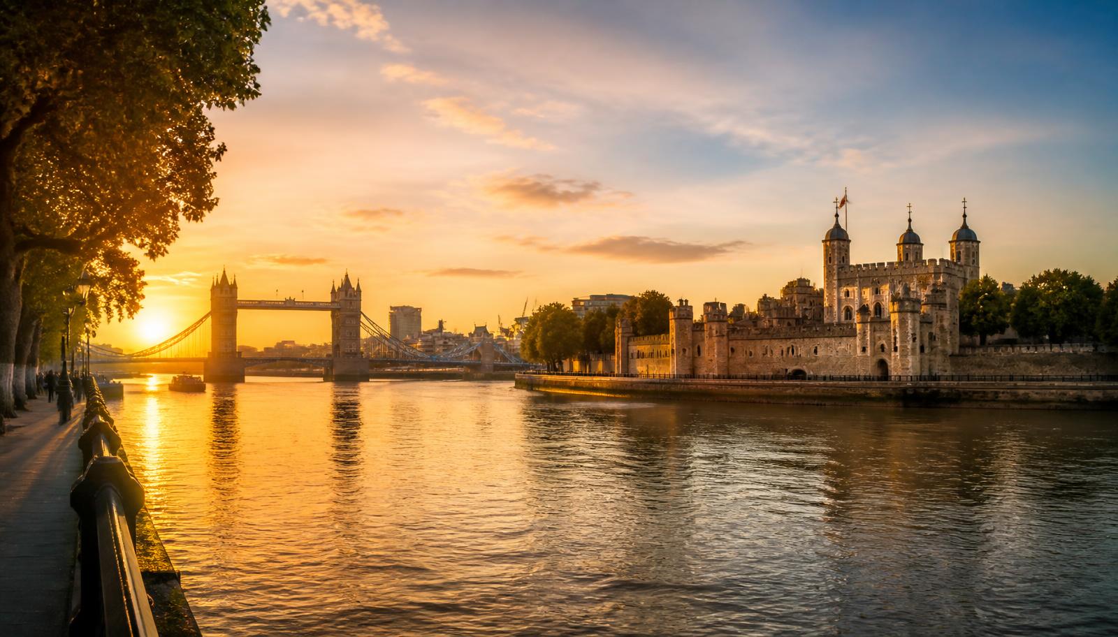 Tower of London and Tower Bridge at sunrise across the River Thames